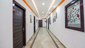 Um corredor com piso em padrão herringbone, iluminação embutida e obras de arte emolduradas nas paredes.