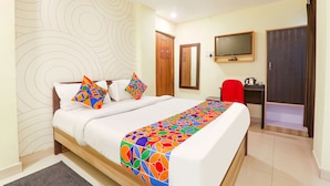 A hotel room with a bed, a TV, a desk, and a wardrobe. - Fabhotel Magadh Regency (Patna)