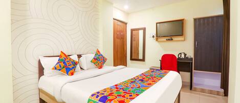 Una habitación de hotel con cama, televisión, escritorio y armario.
