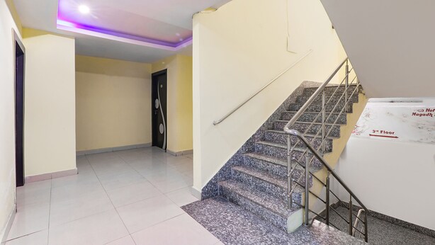 A hotel interior with a staircase leading to the 3rd floor, a ceiling with a built-in light fixture, and a door with a circular handle. - Fabhotel Magadh Regency (Patna)