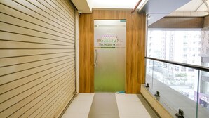A hotel entrance with a wooden door and a green wall.