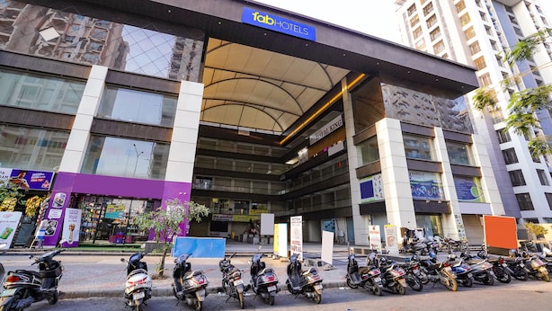A hotel with a modern design, a covered entrance, and multiple floors.