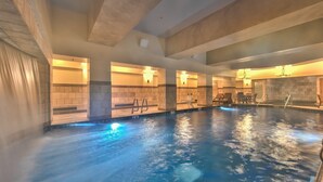 An indoor swimming pool with clear water, tiled walls, and a ceiling with exposed beams. - Westgate Studio, mountain views, resort amenities, multiple pools, tennis, onsite spa, restaurant (Park City)