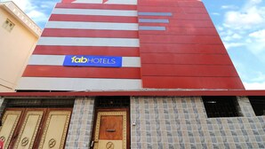 Un edificio con fachada moderna, un llamativo letrero de 'fabHOTELS' y una entrada con mosaicos.
