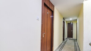Un pasillo con puertas de madera y suelo de mármol.