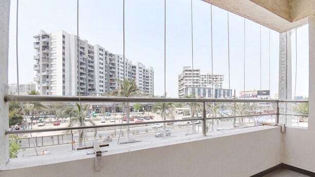 A balcony with a view of a cityscape, including tall buildings and a busy street. - Via Yashraj Inn (Pune)