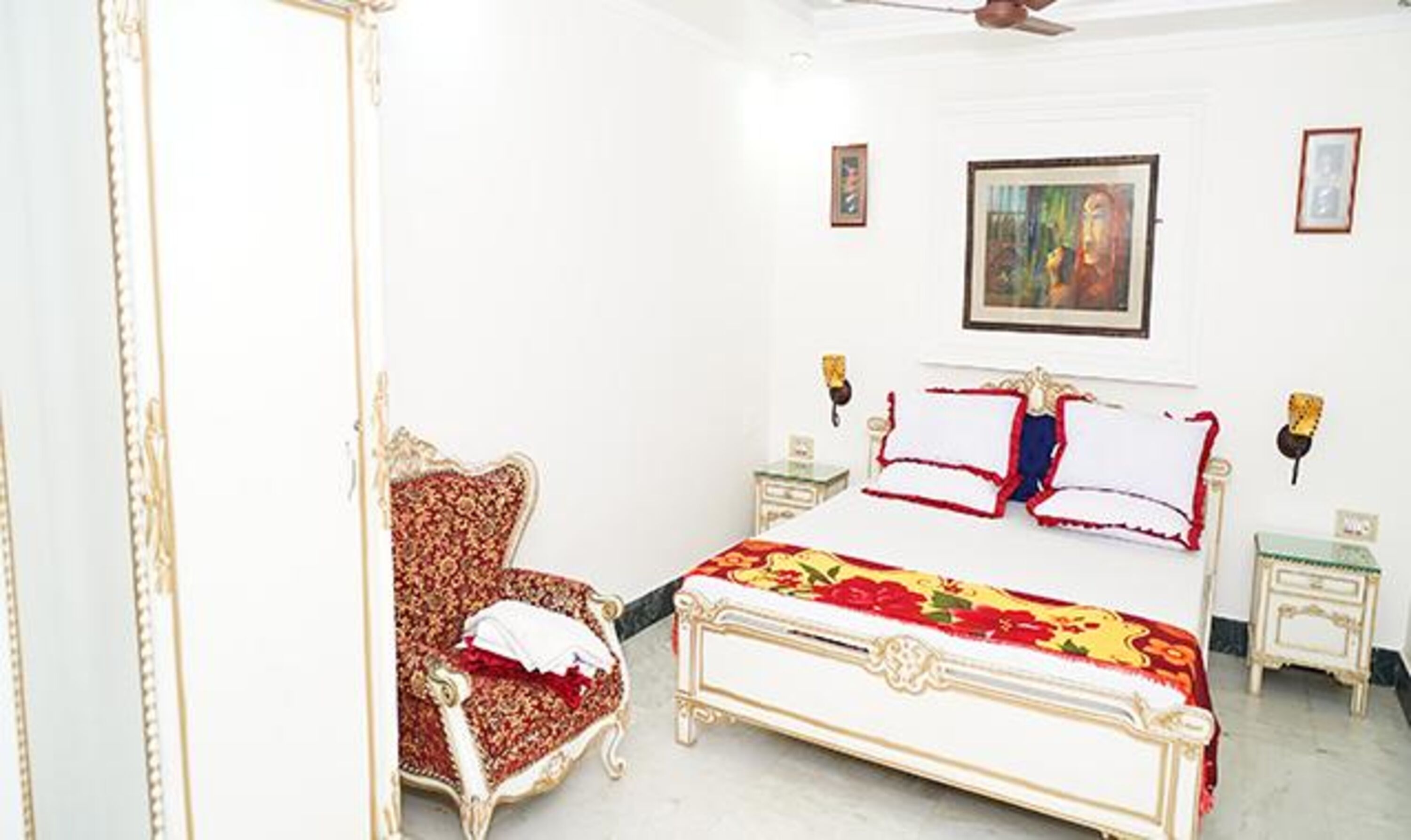 A bedroom with a bed, a chair, and a painting on the wall.