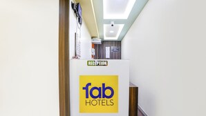 En receptionsdisk med et 'fab hotels' logo og et skilt, der siger 'reception'.