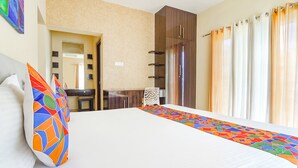 Ein Hotelzimmer mit einem großen Bett, einem Schreibtisch und einem Kleiderschrank.