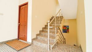 Eine Treppe mit Metallgeländer, einer Holztür und einem farbenfrohen Gemälde an der Wand.