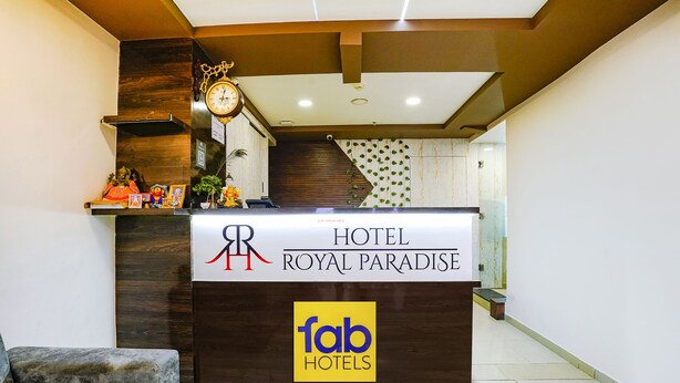 A hotel reception desk with a clock and decorative items. - Fabhotel Royal Paradise (Surat)
