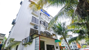 A multi-story building with balconies, air conditioning units, and a sign indicating it is a hotel. - Fabhotel White Palace (Kolkata)