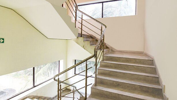 A staircase with metal railings leading to a landing. - Fabhotel White Palace (Kolkata)