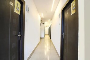 A hallway with doors on both sides, each marked with a 'No Outside Food' sign. - Via Vhyom Sky Place (Kolkata)