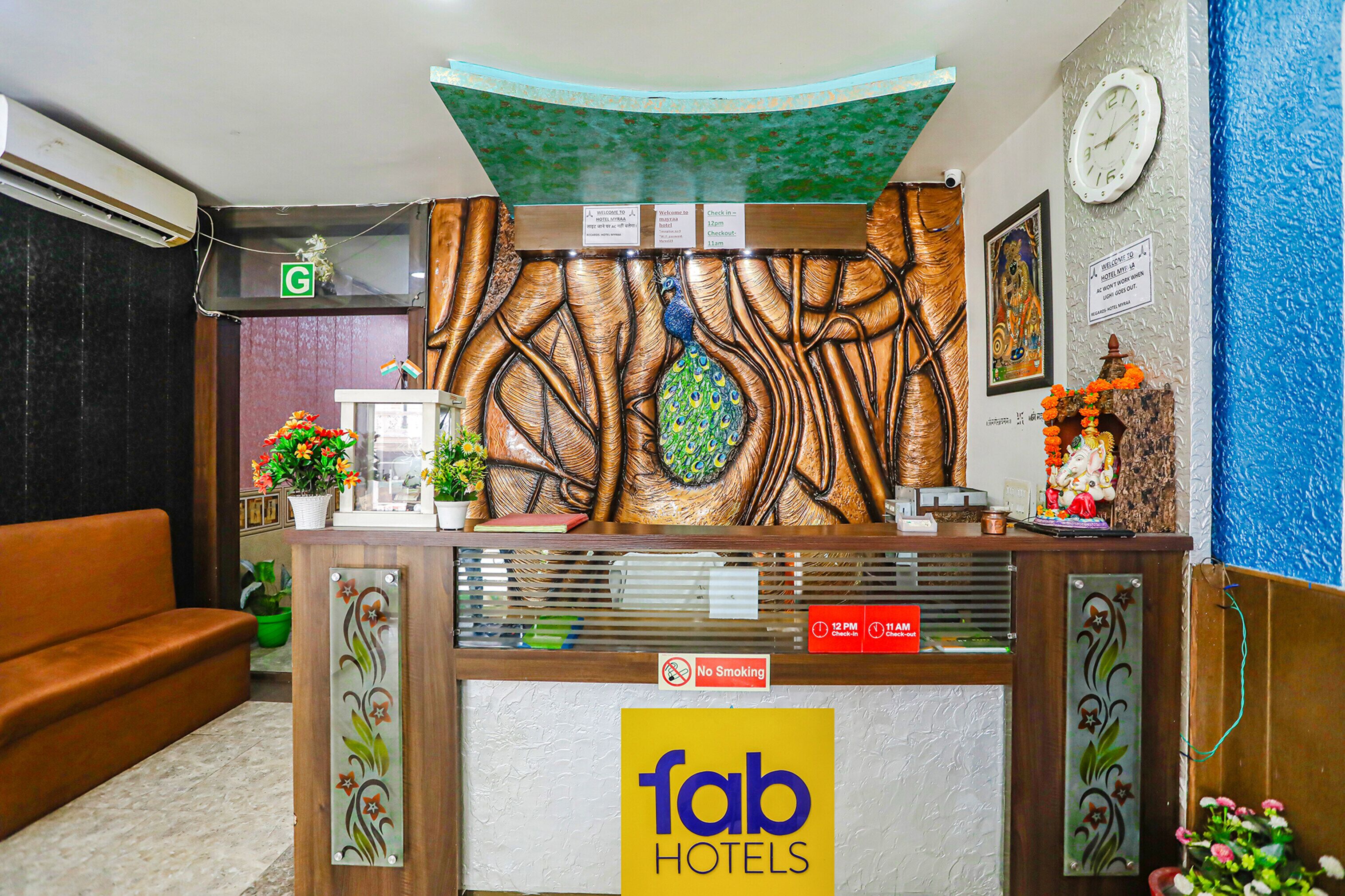 A reception desk with a 'fab hotels' sign, a clock, and a 'no smoking' sign.