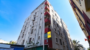A multi-story building with a prominent yellow sign for 'Tab Hotels'. - FabHotel Shri Krishna (Paud)