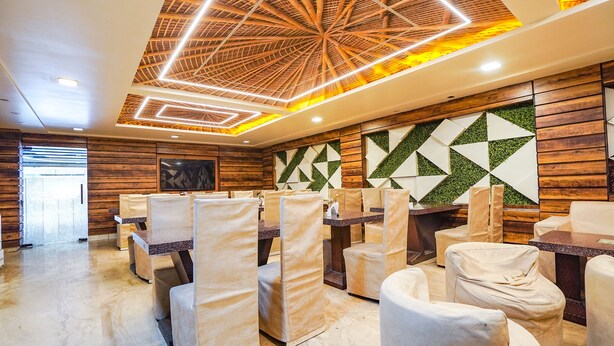 Un restaurante moderno con paneles de madera, arte abstracto en la pared y un diseño de techo único.