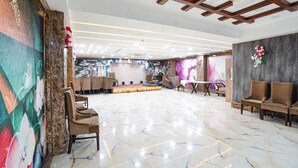 Un amplio salón con escenario, asientos y elementos decorativos.