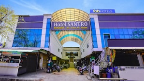 Hotel Santro with a covered entrance, multiple motorcycles parked outside, and a visible staircase leading to the entrance. - Fabhotel Santro (Ahmedabad)