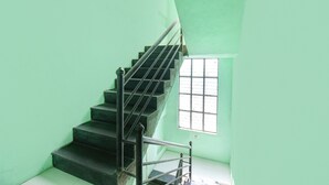 A staircase with metal railings leading to a window with bars. - Fabexpress Ashoka Lodging (Chhatrapati Sambhajinagar)