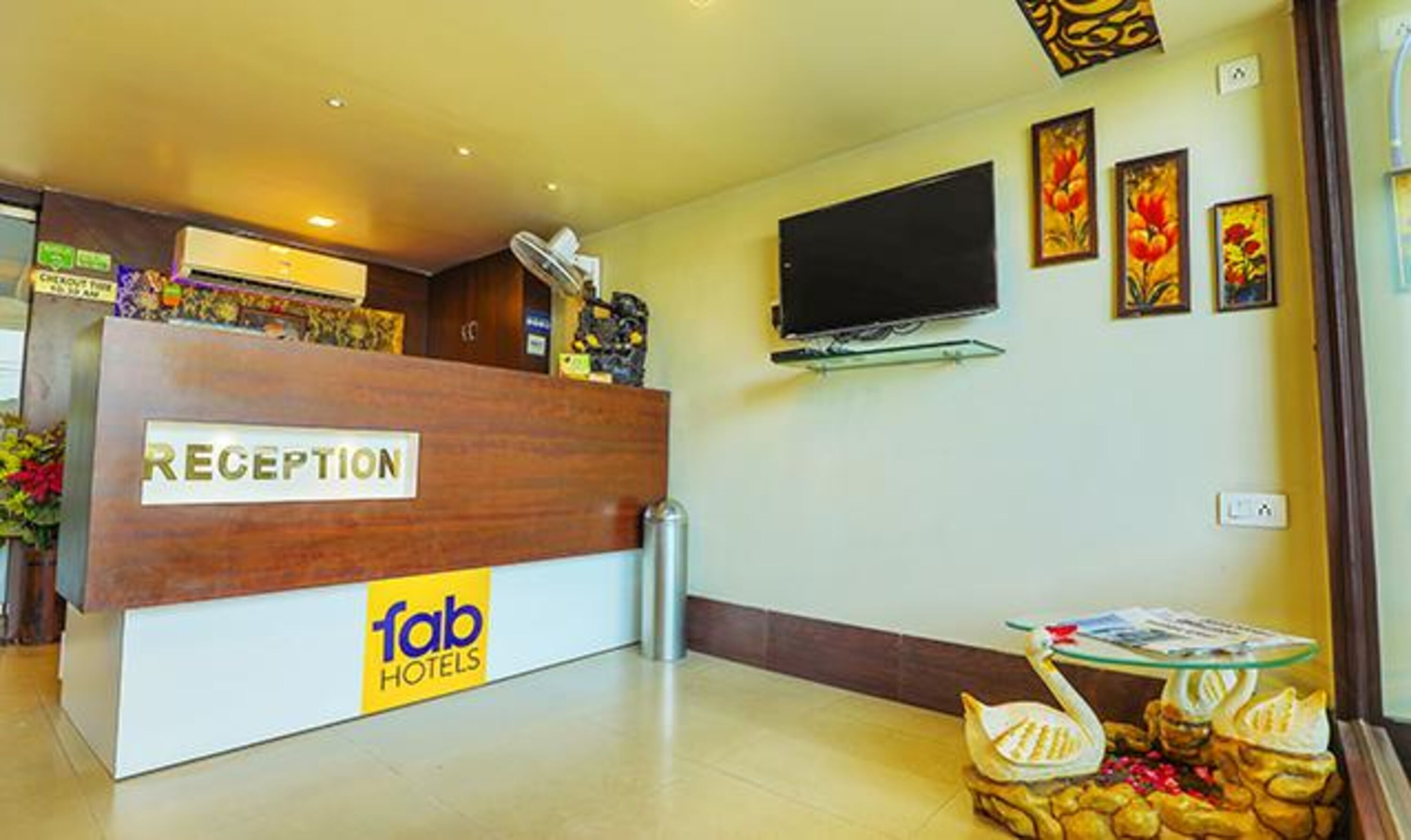 A reception desk with a 'Reception' sign and 'fab hotels' branding.