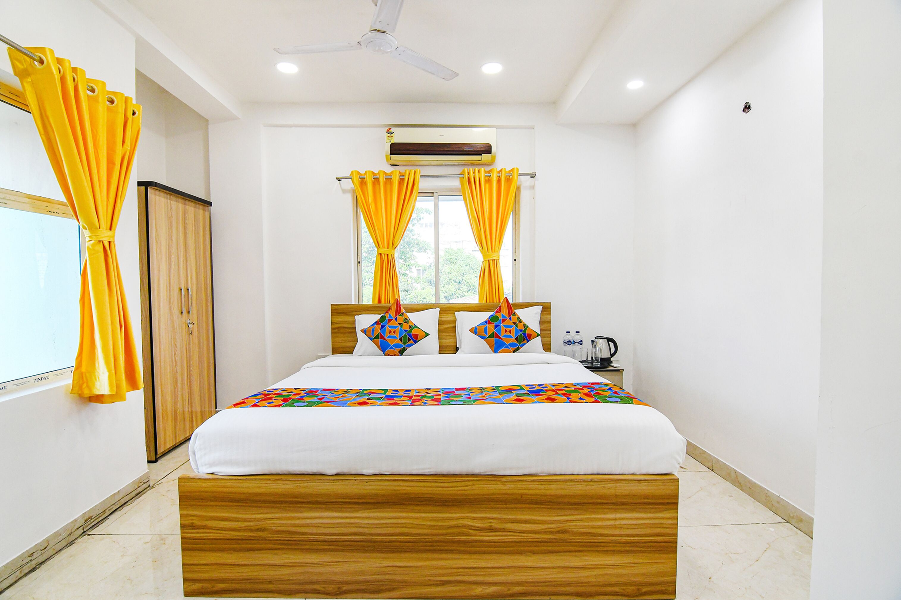 A bedroom with a wooden bed, yellow curtains, and a ceiling fan.