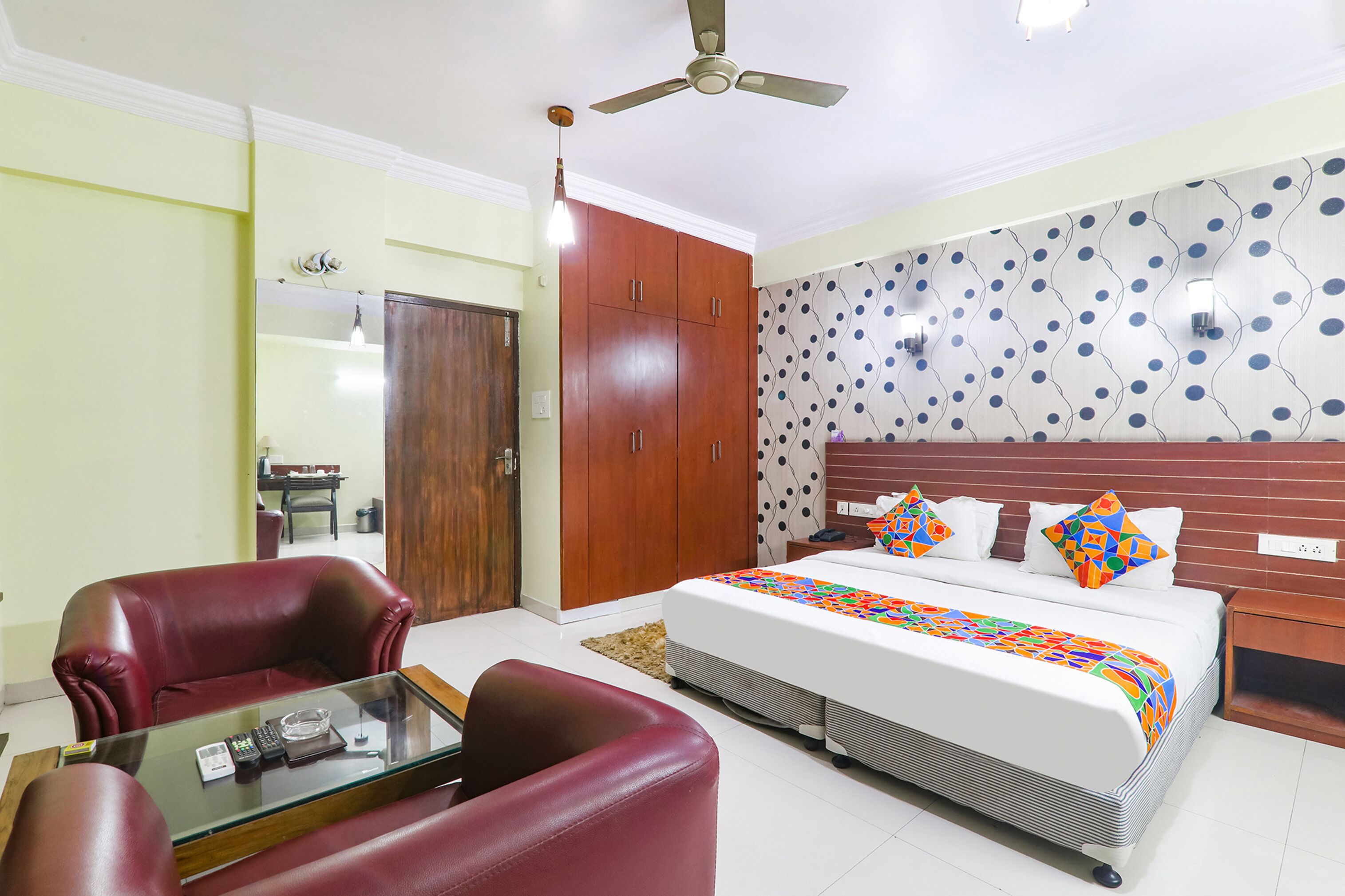 Una habitación de hotel con cama, escritorio, silla y armario.