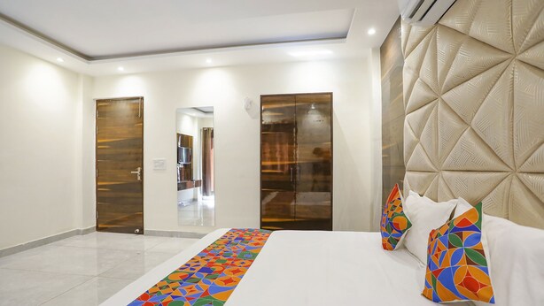 A hotel room with a large bed, a colorful runner, and a headboard with a geometric pattern. - Fabexpress Baba'S Inn (New Delhi)