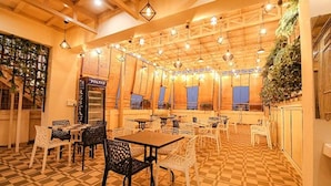 Un espace de restauration intérieur doté d’un sol à carreaux, de tables et de chaises en bois.