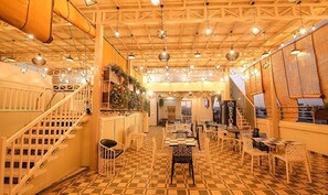 Ein Restaurant mit Schachbrettfußboden, Holzboden und hängenden Pendelleuchten.