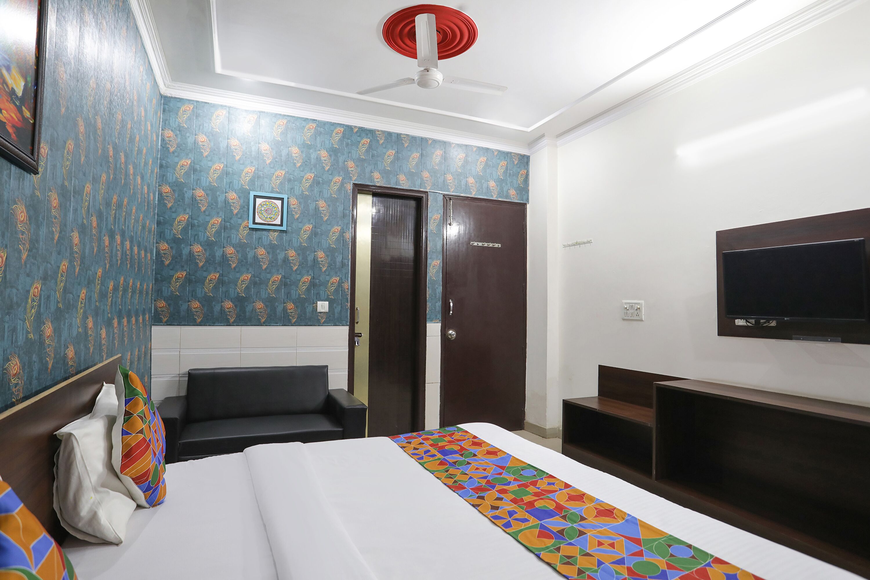 A hotel room with a bed, a TV, a desk, and a wardrobe.