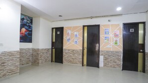 A hallway with four doors, numbered 7 and 8, and a wall with educational posters. - Fabexpress Chef'S House (Gurugram)