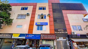 A multi-story building with various businesses including a hotel named 'Vishesh Villas' and a hotel named 'Fab Hotels'. - Fabhotel Vishesh Villas (New Delhi)