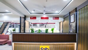 A reception area with a modern design, including a reception desk, a ceiling fan, and a sign indicating free WiFi availability. - Fabhotel Amogh Stay Inn (Nagpur)