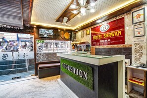 A hotel reception area with a reception desk, a sign for Hotel Sarwan, and an exit sign. - Fabhotel Sarwan (Agra)