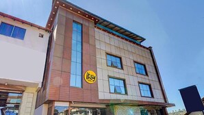 A multi-story building with a modern architectural design, featuring a mix of brick and glass facades. - Fabhotel Hill View (Madikeri)