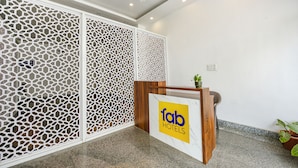 Uma área de recepção com uma mesa de madeira e uma placa que diz 'fab HOTELS'.