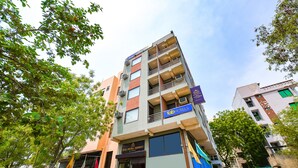 Un hôtel à plusieurs étages doté de balcons, une enseigne indiquant « Tab Hotels » et une autre indiquant « Hotel Drakara Residency ».