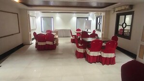 A conference room with a large table and red chairs, white walls, and a ceiling with recessed lighting. - Fabhotel Satlaj (Raipur)