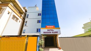 Un hotel anomenat 'Hotel Magadh Glory' amb una façana destacada i un rètol de 'Fabexpress'.