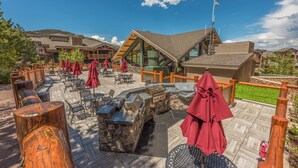 A patio area with outdoor seating, a barbecue station, and a view of the surrounding buildings. - Ski in/out at Westgate Studio, Resort amenities, Multiple Pools, Onsite Spa, & Restaurant 3912B (Park City)