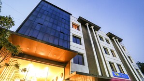 A modern hotel building with a prominent glass facade, a sign indicating it is a hotel, and a visible entrance with a well-lit interior. - Fabhotel Prime Mahendra (Raipur)