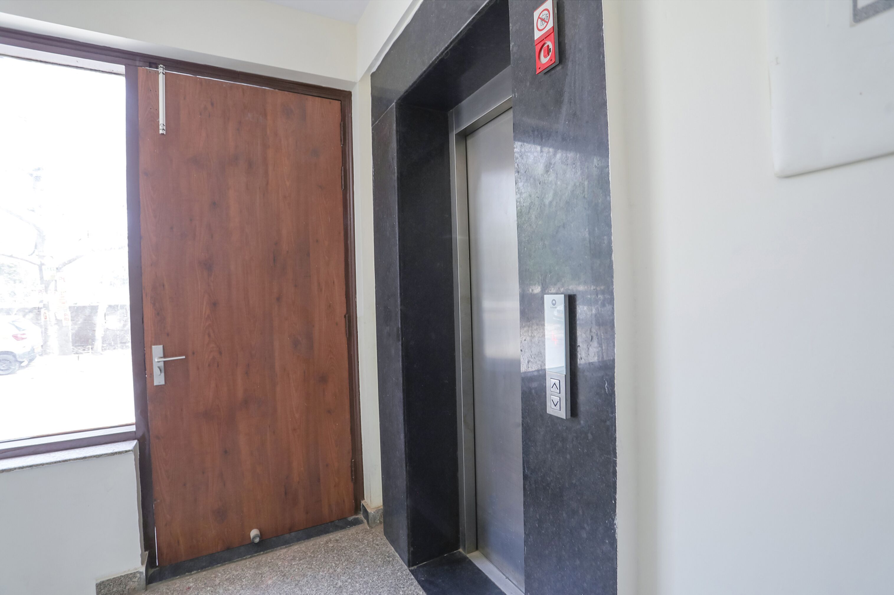 Una puerta de madera y un moderno ascensor con panel de control.