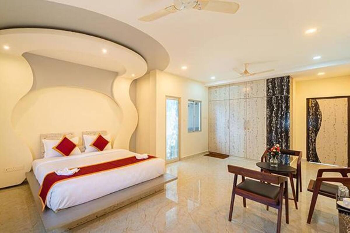 Une chambre d’hôtel moderne dotée d’un grand lit, d’un coin repas et d’une salle de bain avec un grand miroir.