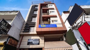 Ein mehrstöckiges Gebäude mit Schildern für "Sky High Hotel & Banquet" und "Tab Hotels".