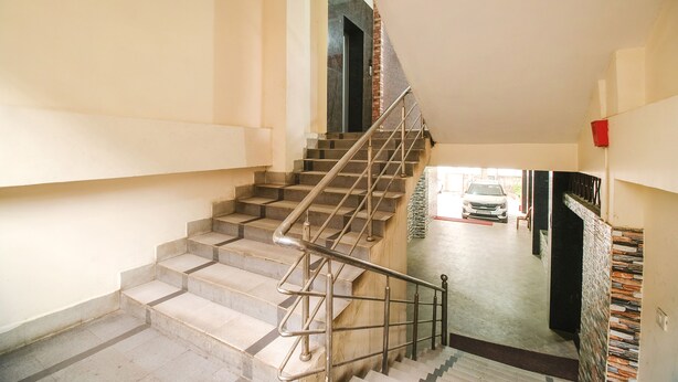 Una escalera con barandillas de metal que sube a un piso superior.