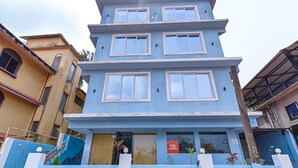 A multi-story building with a blue facade, multiple windows, and a visible storefront with a sign. - Fabexpress Springs (Alto de Porvorim)