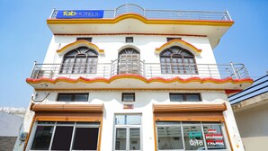 Un hotel con un cartel que dice "Tab Hotels" y un cartel anunciando "Maa Vaishno Devi Palace".