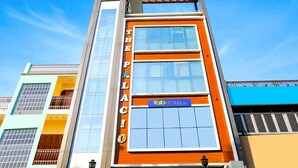 Un hotel de varios pisos con un letrero llamativo que dice "THE PALACE" y un letrero de "Tab Hotels" en el segundo piso.
