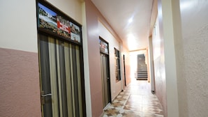 A hallway with patterned flooring, doors, and a staircase at the end. - Fabexpress Galaxy (Kharar)